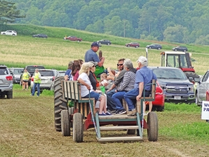 Tractors and wagons carried groups of people to and from the parking area at the Sauk County Dairy Breakfast. This year’s event was held at Narrows Dairy outside Rock Springs last Saturday morning. In the background, you can see cars lined up for miles to enter the grounds for the breakfast. (Photos by Heather Stanek)