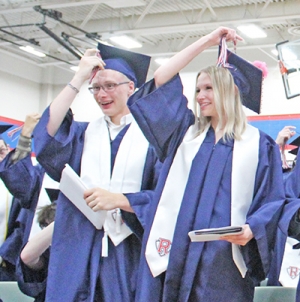 Students turn the cords on their hats after collecting their diplomas.