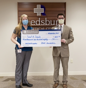 Jody Berndt, public health technician at Sauk County Seal-A-Smile receives the check from Ryan Shear, RAMC VP. To date, RAMC has given $18,680 to the program, which provides dental screenings and treatments, oral health education and hygiene supplies to Sauk County children at no cost to their families. (Submitted photo)
